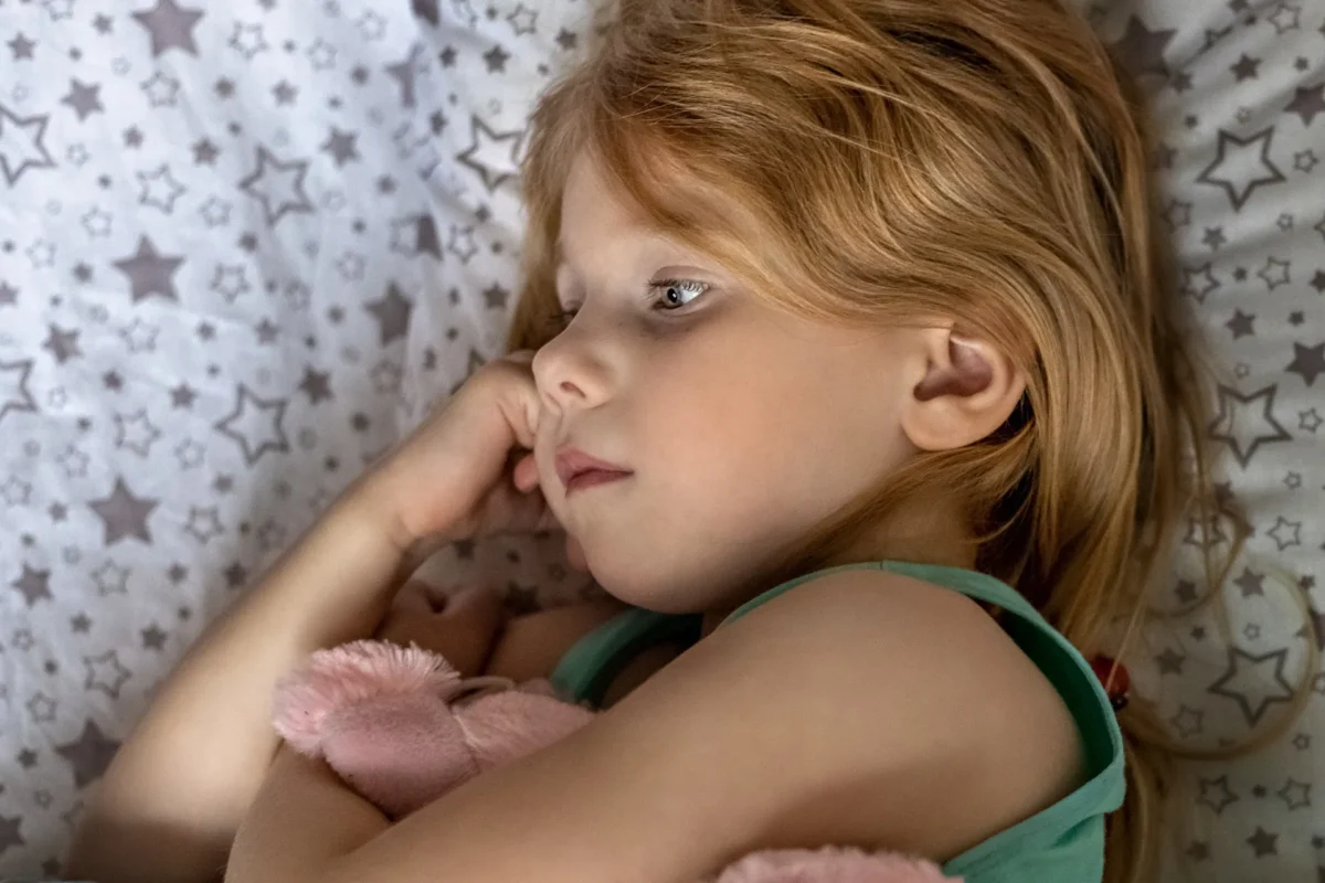 Kind liegt wach im Bett bei Schlafprobleme Kinder