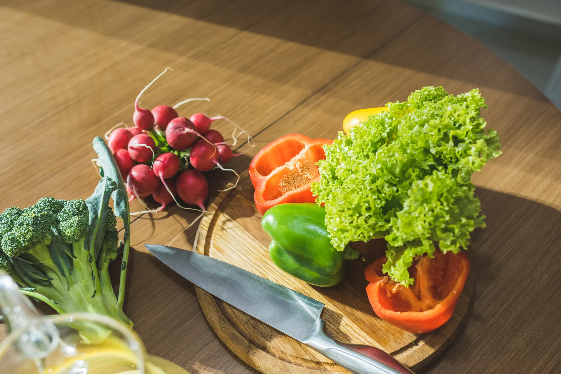 Brokkoli, Radieschen, Paprika und Salat auf einem Holzbrett – leichte, magenschonende Ernährung zum Sodbrennen lindern